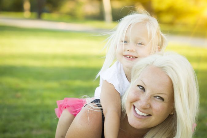Mother and Little Girl Having Fun Together in Grass