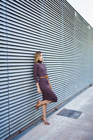 Professional woman leaning on wall