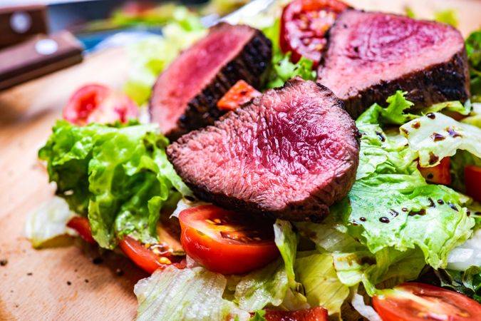 Juicy steak salad with fresh lettuce and tomatoes served with cutlery