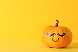 Pumpkin with smile on yellow background, space for text