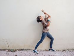 Excited kid raising hands up with ukulele