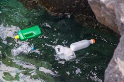 Plastic bottles and bag floating on water