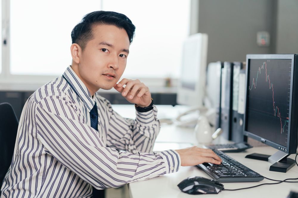 Serious Asian businessman trader looking at camera