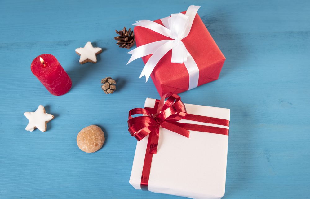 Gifts and lit candle on blue table