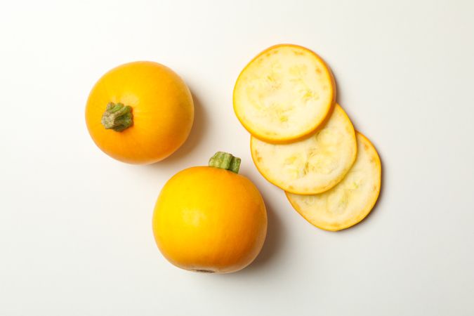 Round zucchini and slices on blank background, top view