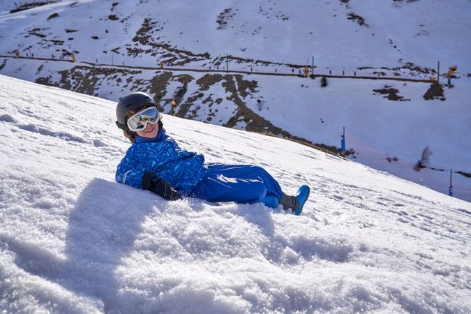 Child lying on snowy slope
