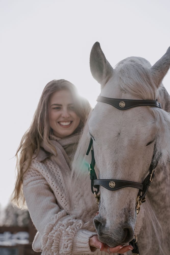 Warm dressed woman with gray horse outside