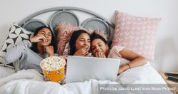 Young women having fun watching movie on laptop eating popcorn in bed 5kEGQb