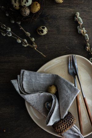 Top view of Easter table setting with quail eggs and pussy willow branches