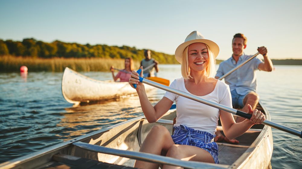 Woman smiling on a canoe with a group of friends