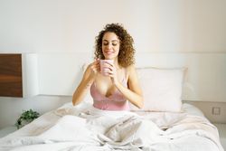 Woman sipping coffee in bed
