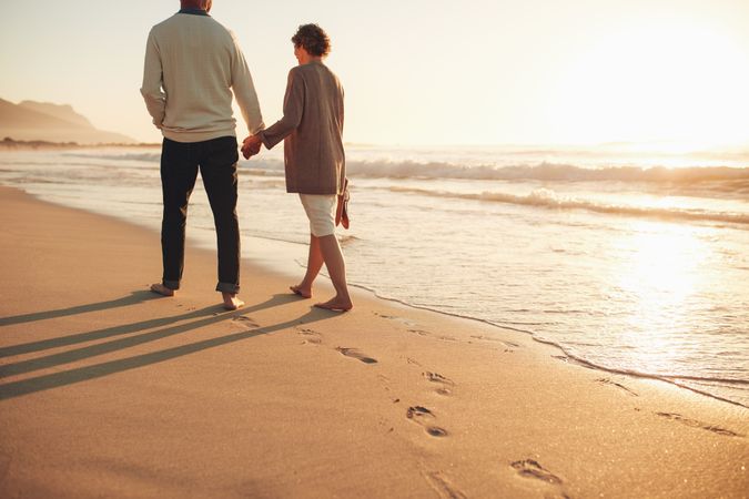 Rear view of a couple walking along the sea shore
