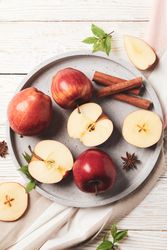 Looking down at plate of apples, anise and cinnamon sticks, vertical