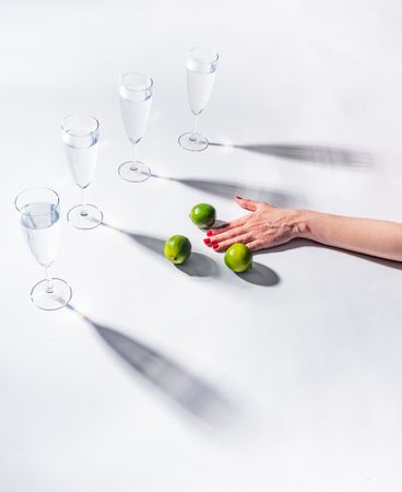 Composition of a hand with citrus and glasses of water
