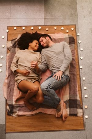 Multiethnic couple kissing on floor