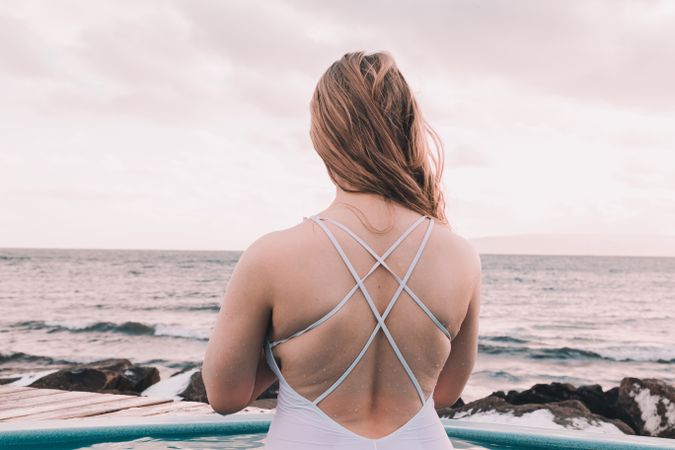 Woman sitting in pool near stones