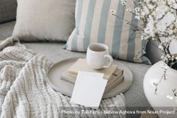 Chic interior still life with cup of coffee, tea on pile of books on tray with mock up card 5q6w14