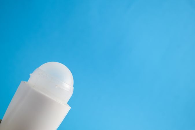 Deodorant bottle against a blue background