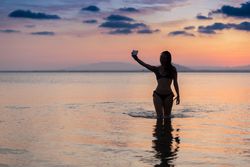 Seductive female taking selfie in water