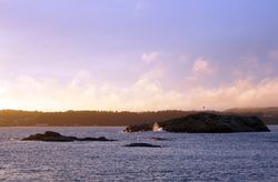 Rocky shore of tranquil sea in dusk
