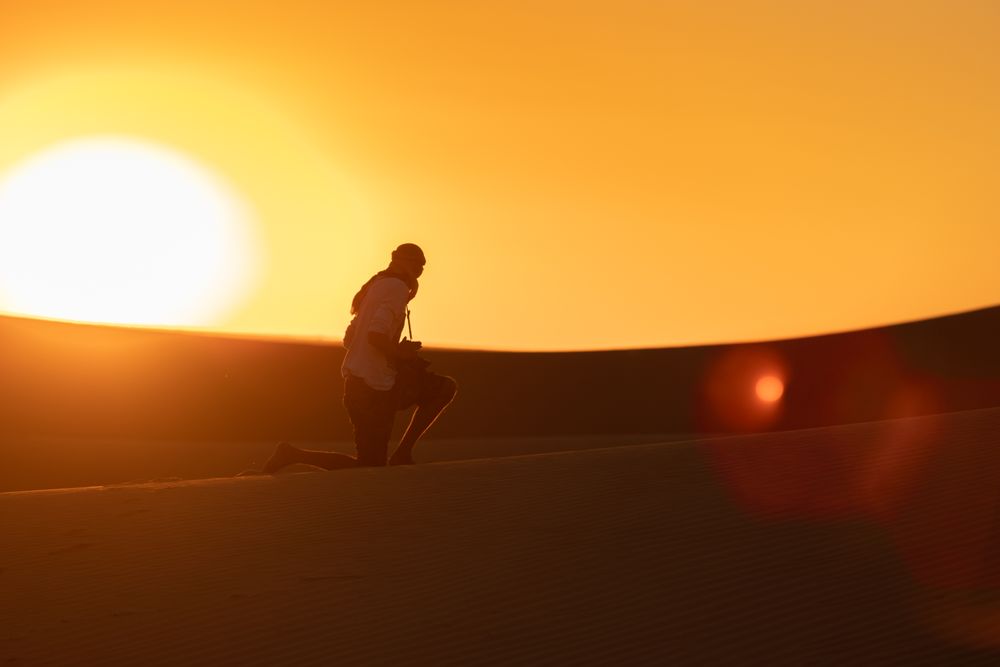 Anonymous photographer standing in desert