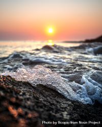 Ocean waves crashing on shore during sunrise in macro photography 48nAK0