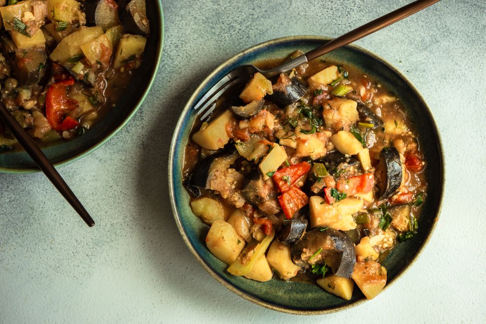 Top view of Georgian summer and autumnal dish Ajapsandali with vegetables on grey counter with copy space