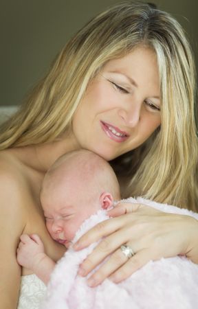 Young Smiling Mother Holding Her Precious Newborn Baby Girl