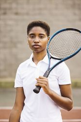 Young women with a racket in a tennis court