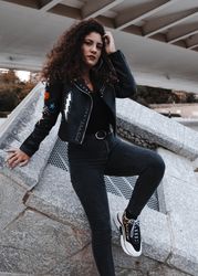 Modern woman in jacket and jeans standing in city