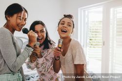 Young women enjoying singing karaoke during a sleepover 499VW4