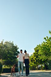 Couple walking and playing with their dog