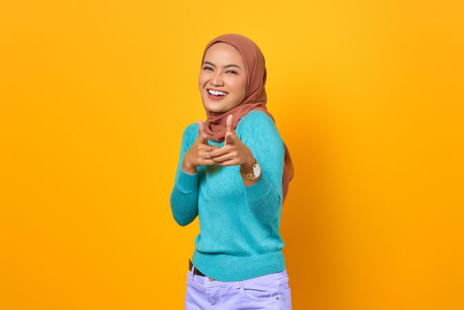 Smiling Muslim woman pointing at camera