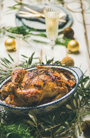 Roast chicken with festive decorations and crystal flute of champagne