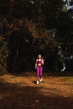 Young woman jogging in forest path