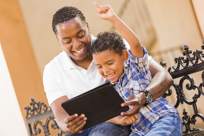 Happy Father and Son Using Tablet On Balcony