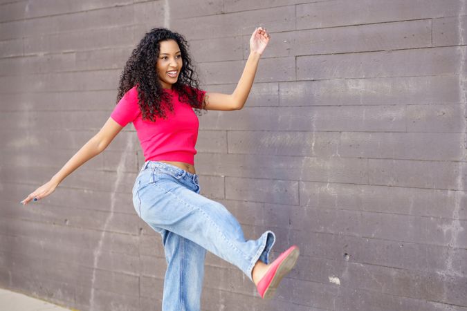A Stylish Young Woman Joyfully Dancing in a Colorful Urban Setting, Brimming with Energy