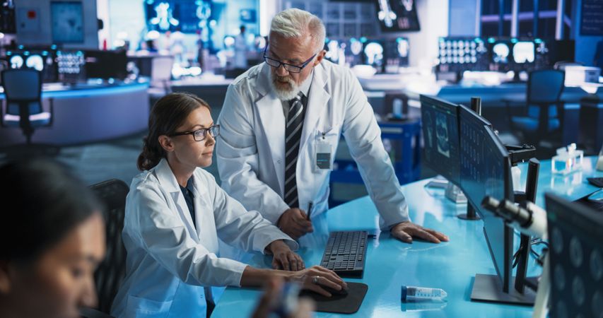 Biotechnology Research Laboratory: Two Doctors Discussing CT Brain Scan On Computer.
