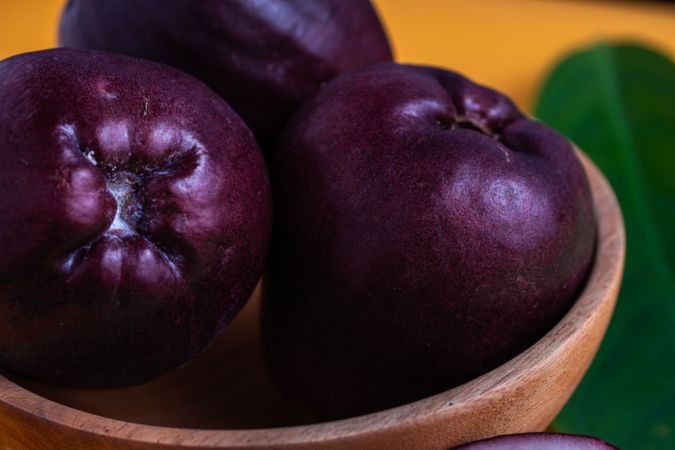 Three Syzygium malaccense or known as jambu jamaika fruits are on a yellow background