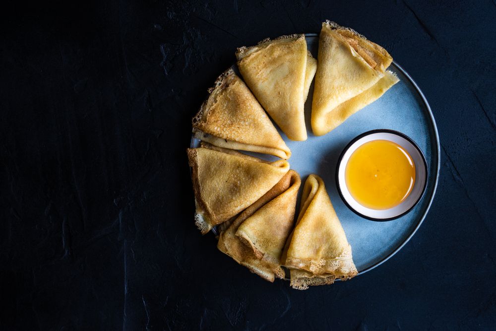 Top view of plate of pancakes with honey