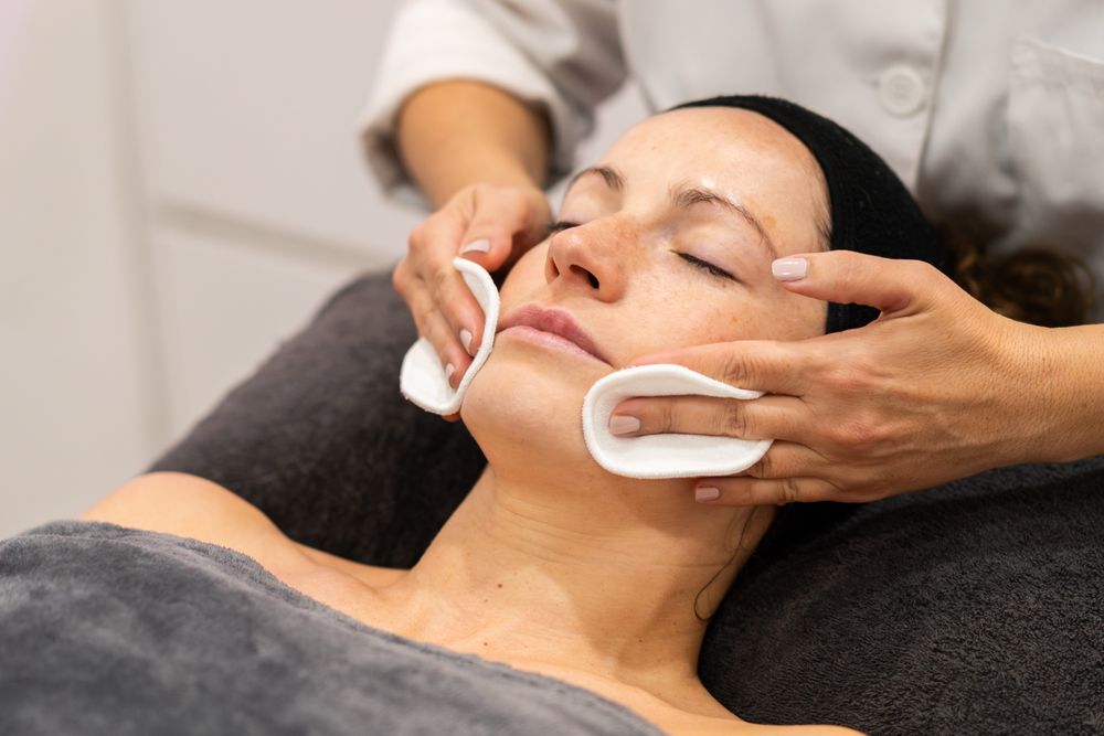 Woman having face cleansed during facial