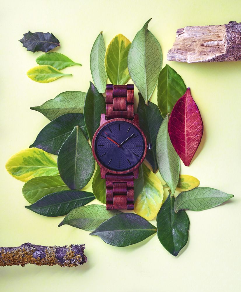 Wrist watch on top of leaves on a table