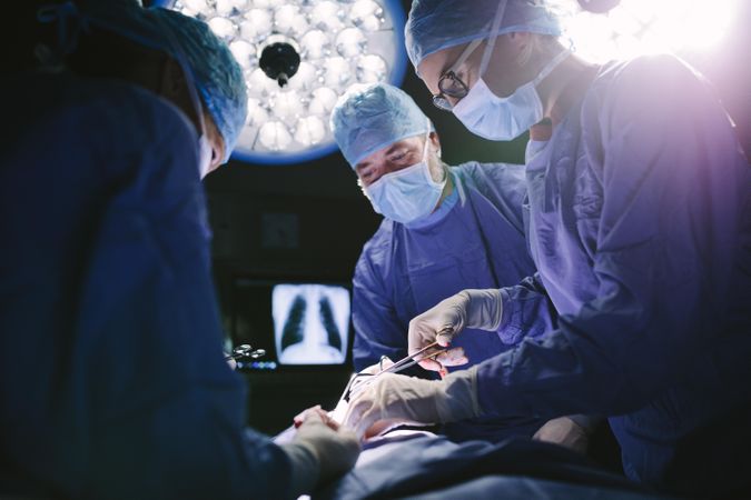 Medical team performing surgical procedure in operating theater