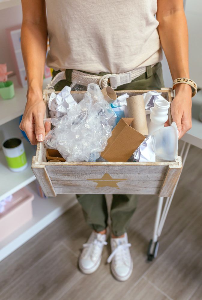 Female teacher showing a box of waste to recycle in ecology classroom
