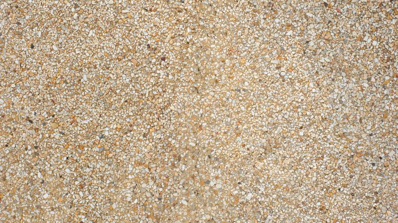 Light terrazzo stone surface with small marble fragments and polished texture