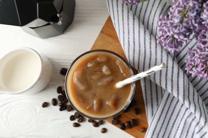 Composition with ice coffee and flowers on wooden background