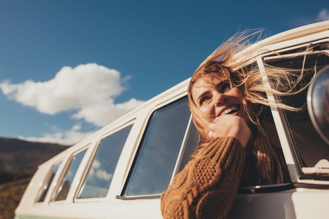 Woman driving a van and enjoying road trip