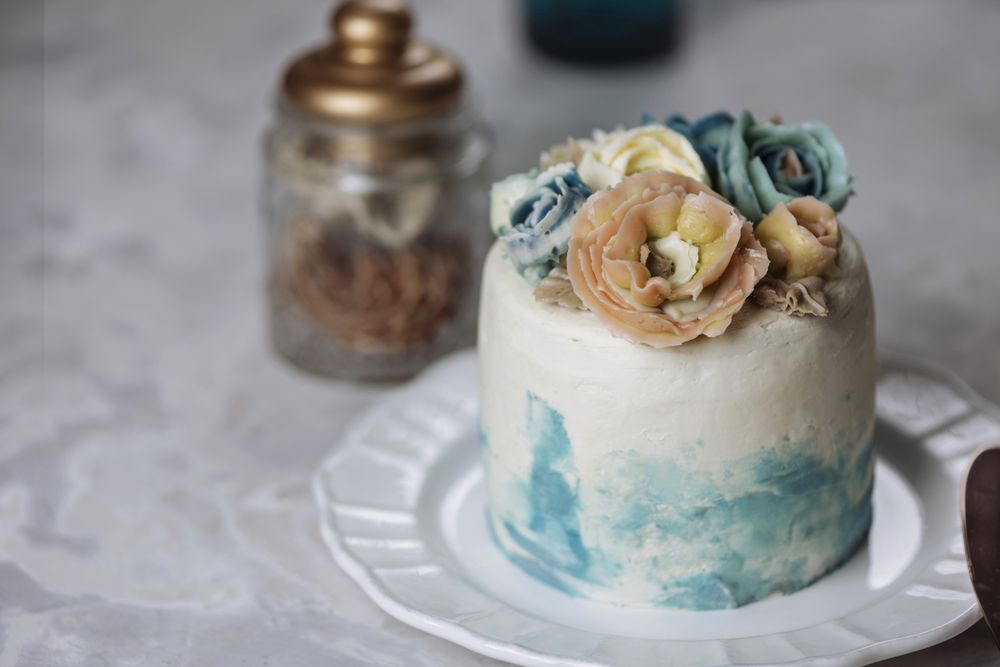Buttercream flowers cake, blue and pastel peach colors