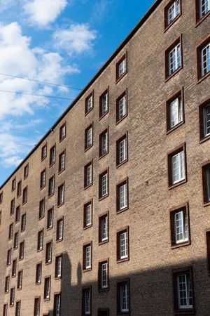 Windows on minimal brown brick building under blue sky
