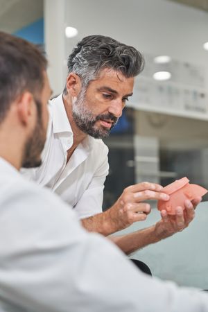Engineer examining respirator near colleague